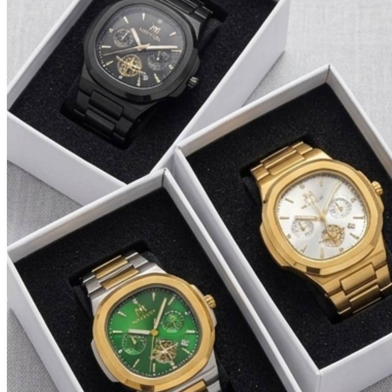 Three luxury wristwatches with automatic skeleton dials displayed in their white gift boxes. The watches feature black, gold, and green cases and dials, set against a light gray textured background.