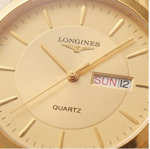 Close-up of a Longines Quartz watch dial in gold-tone metal, showing the brand name, wing logo, hour markers, hands, and a day/date window displaying SUN 12.